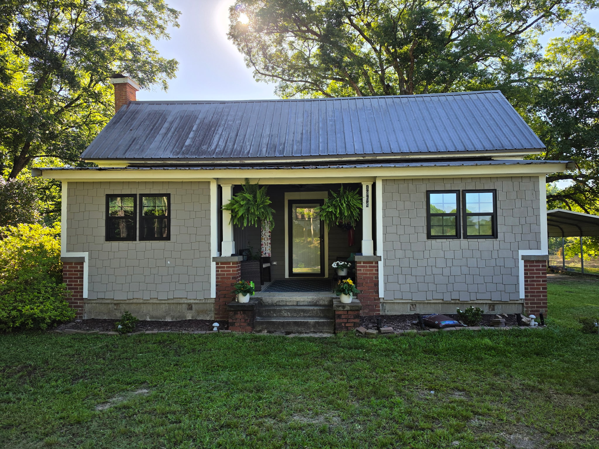 Home exterior renovation with new siding, windows and covered front porch