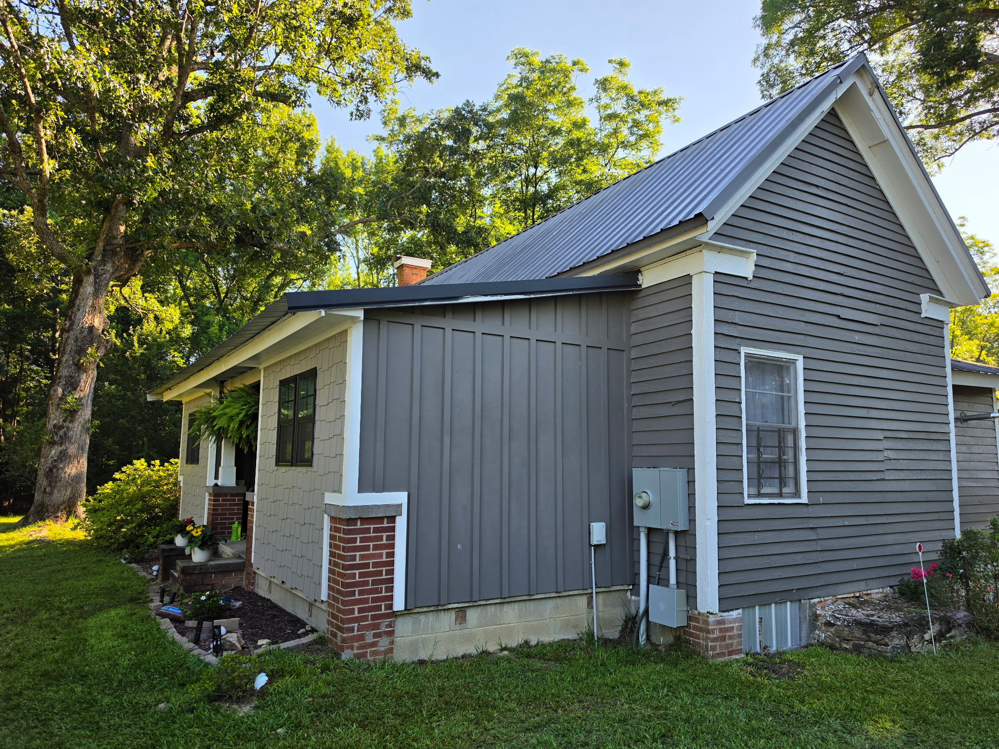 Home addition with new board-and-batten siding and metal roof extension