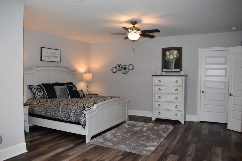 Finished basement bedroom with dark hardwood floors and ceiling fan