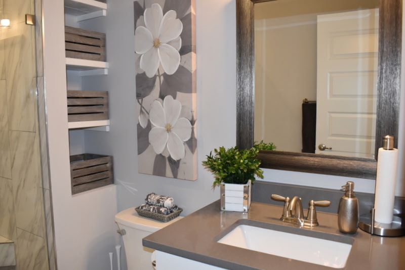 Finished basement bathroom with gray vanity and marble tile shower