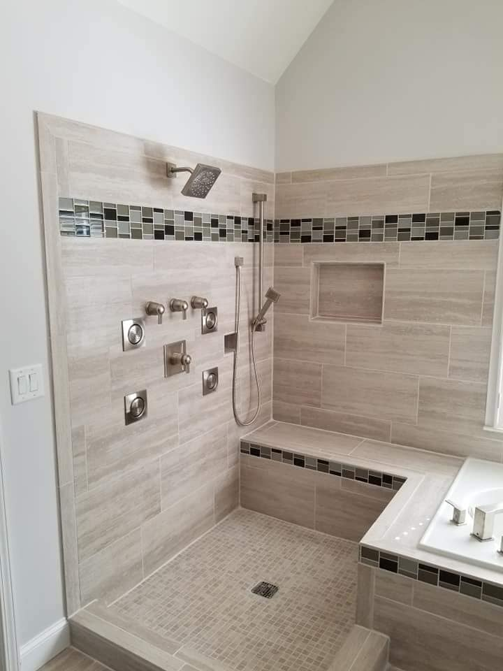 Walk-in shower with body jets, glass tile accent band and bench
