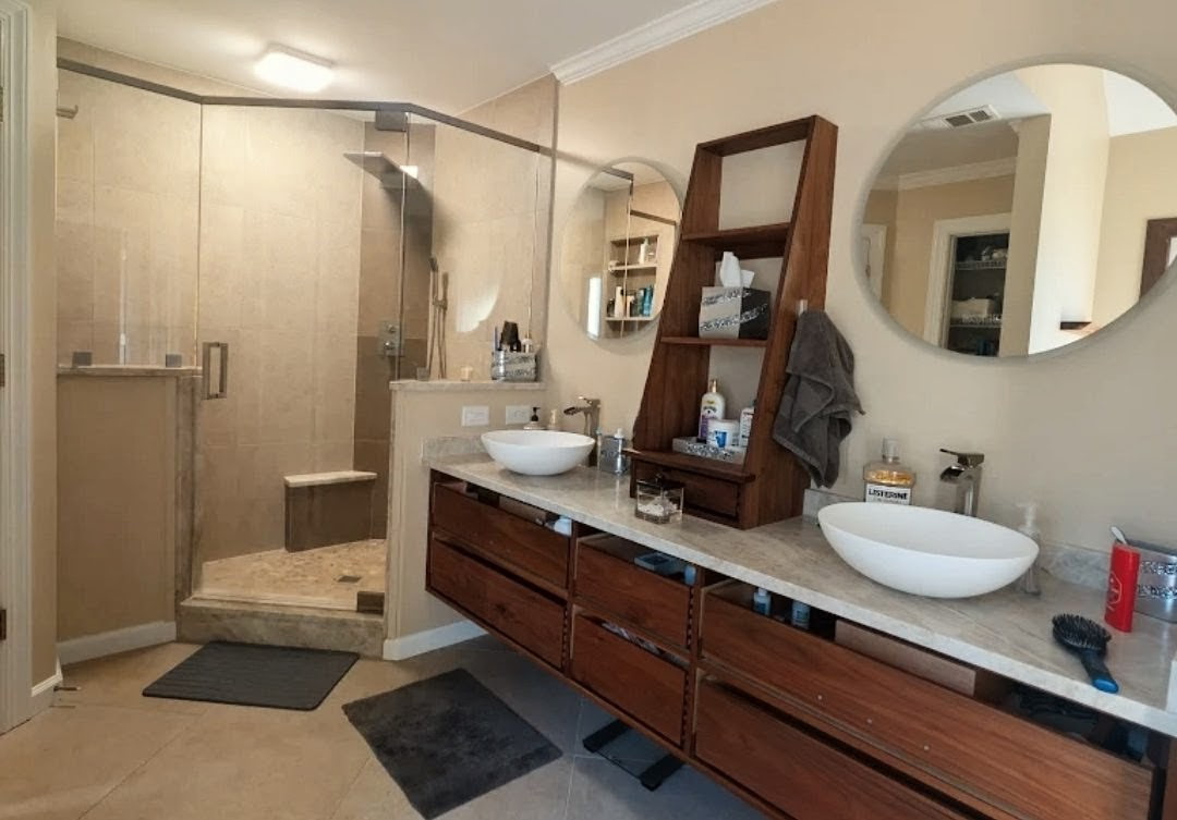 Master bathroom with custom walnut floating vanity, vessel sinks and corner glass shower