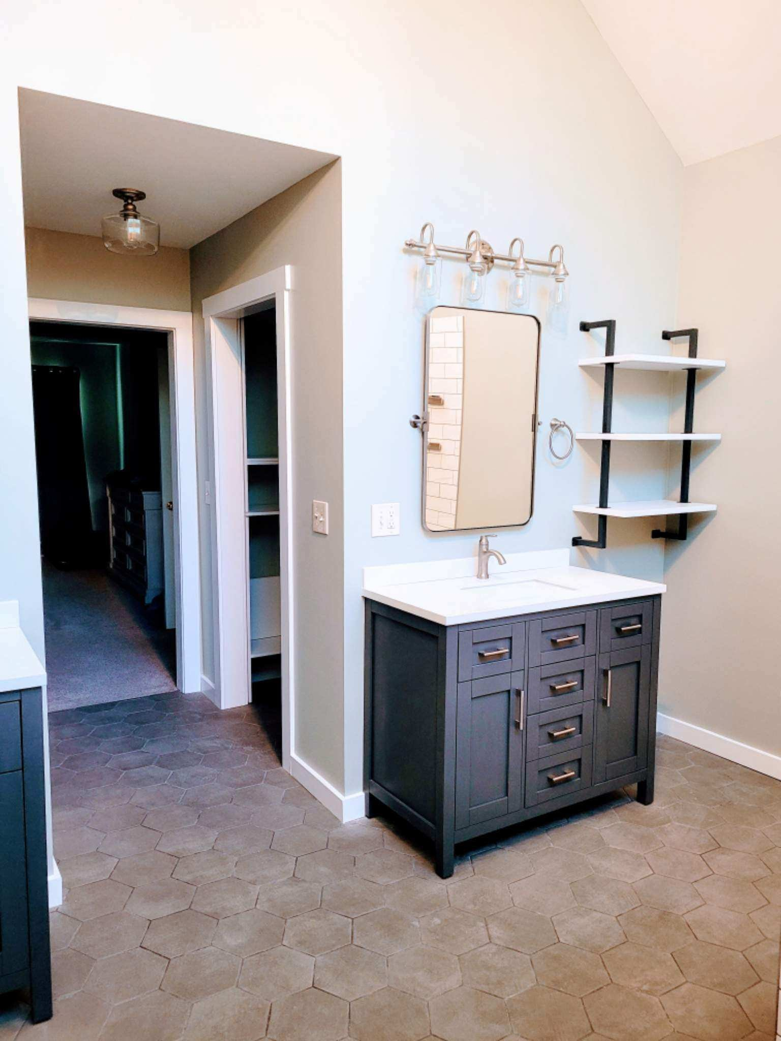Dark navy vanity with quartz countertop and hex tile flooring
