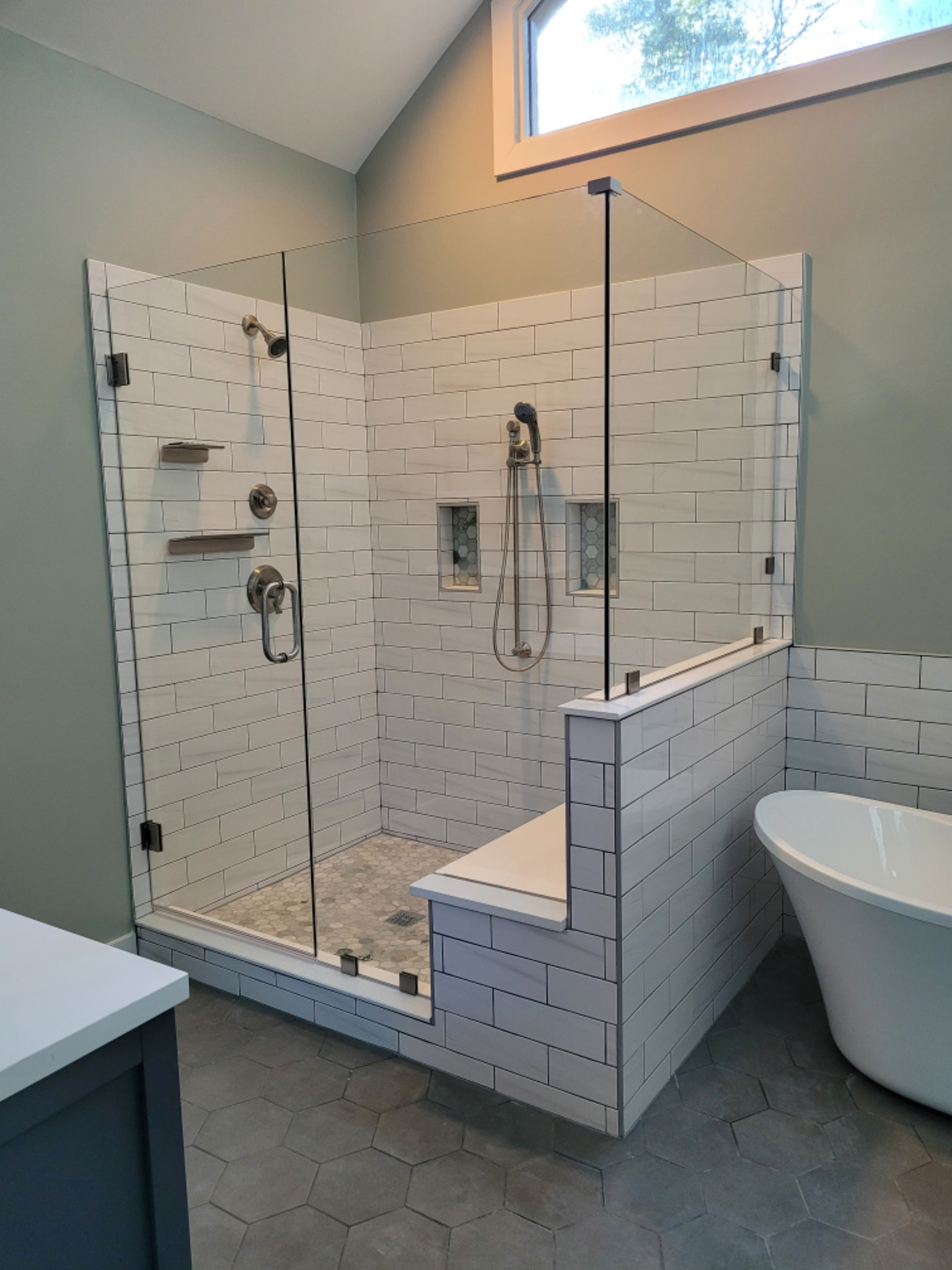 Custom glass walk-in shower with subway tile and soaking tub