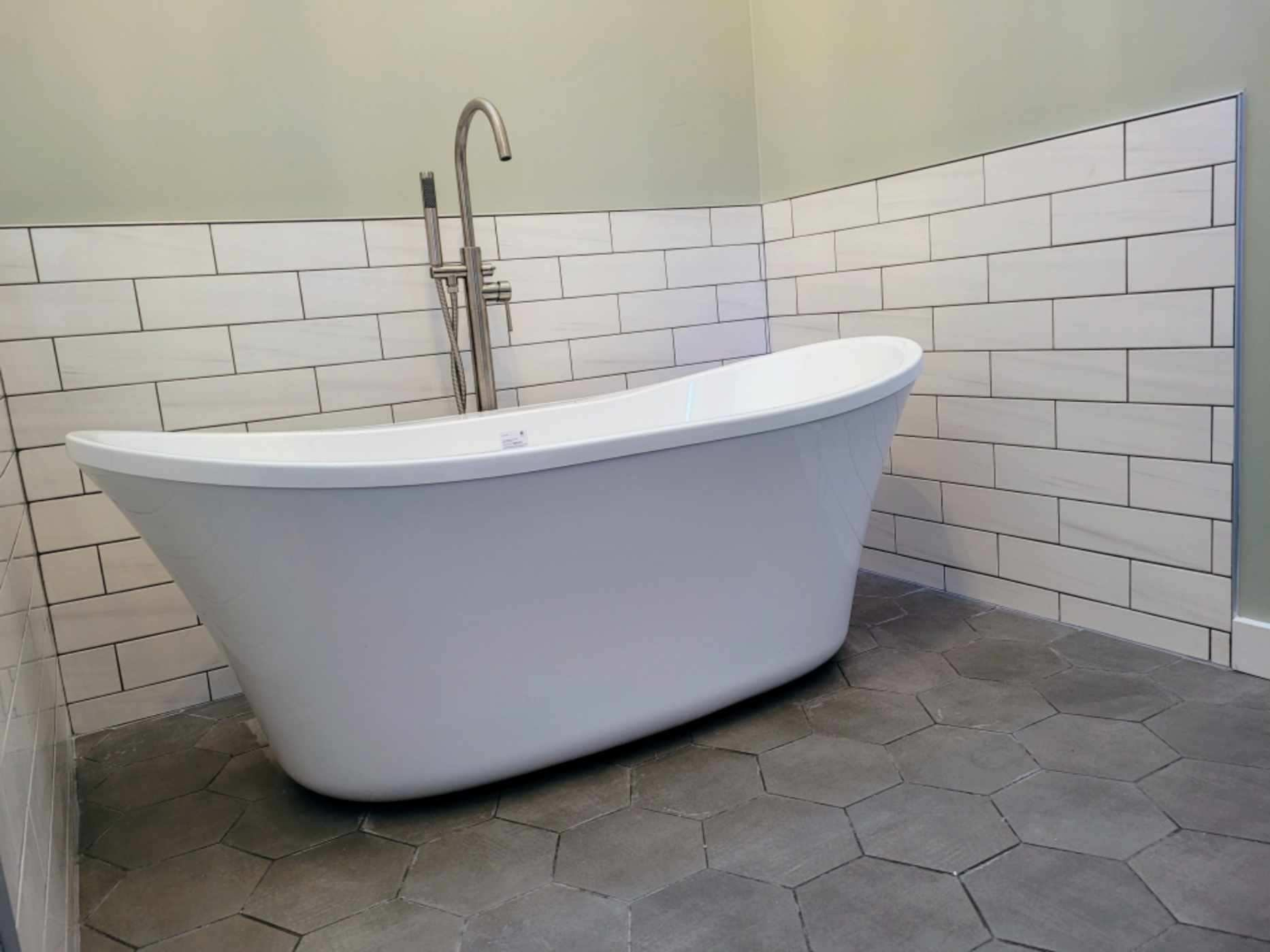 Freestanding tub with subway tile surround and floor mount faucet