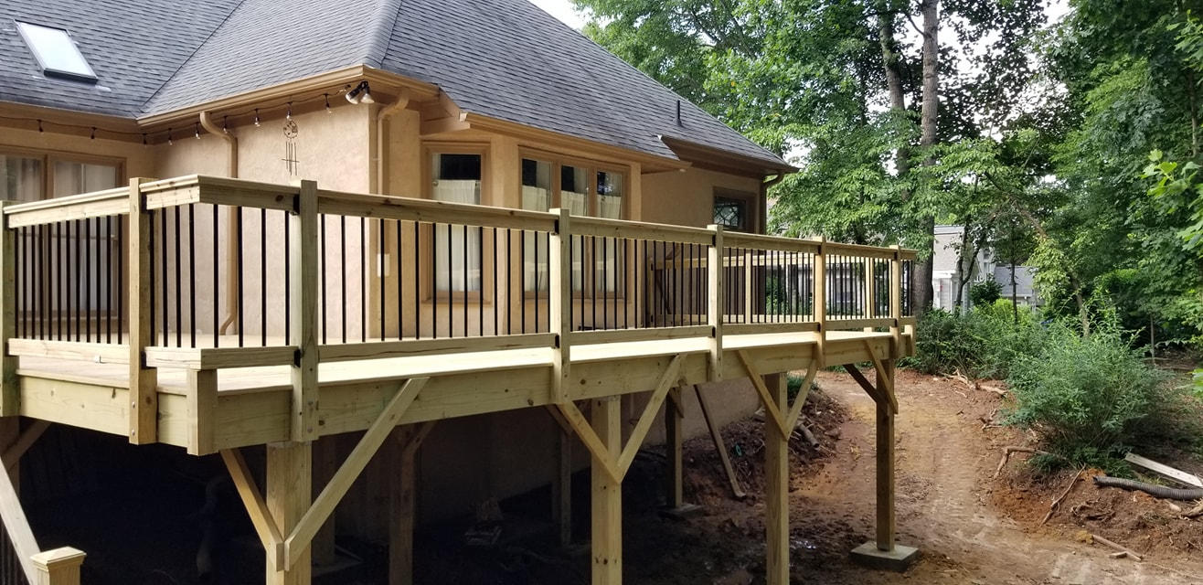 Elevated wood deck with black metal balusters on two-story home