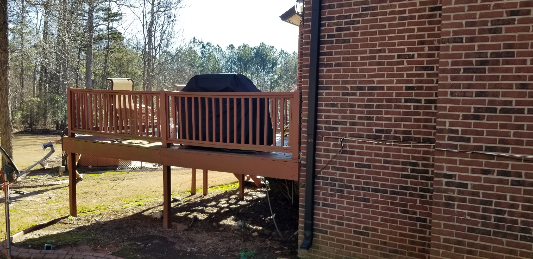 Deck with grille and wooded backyard view