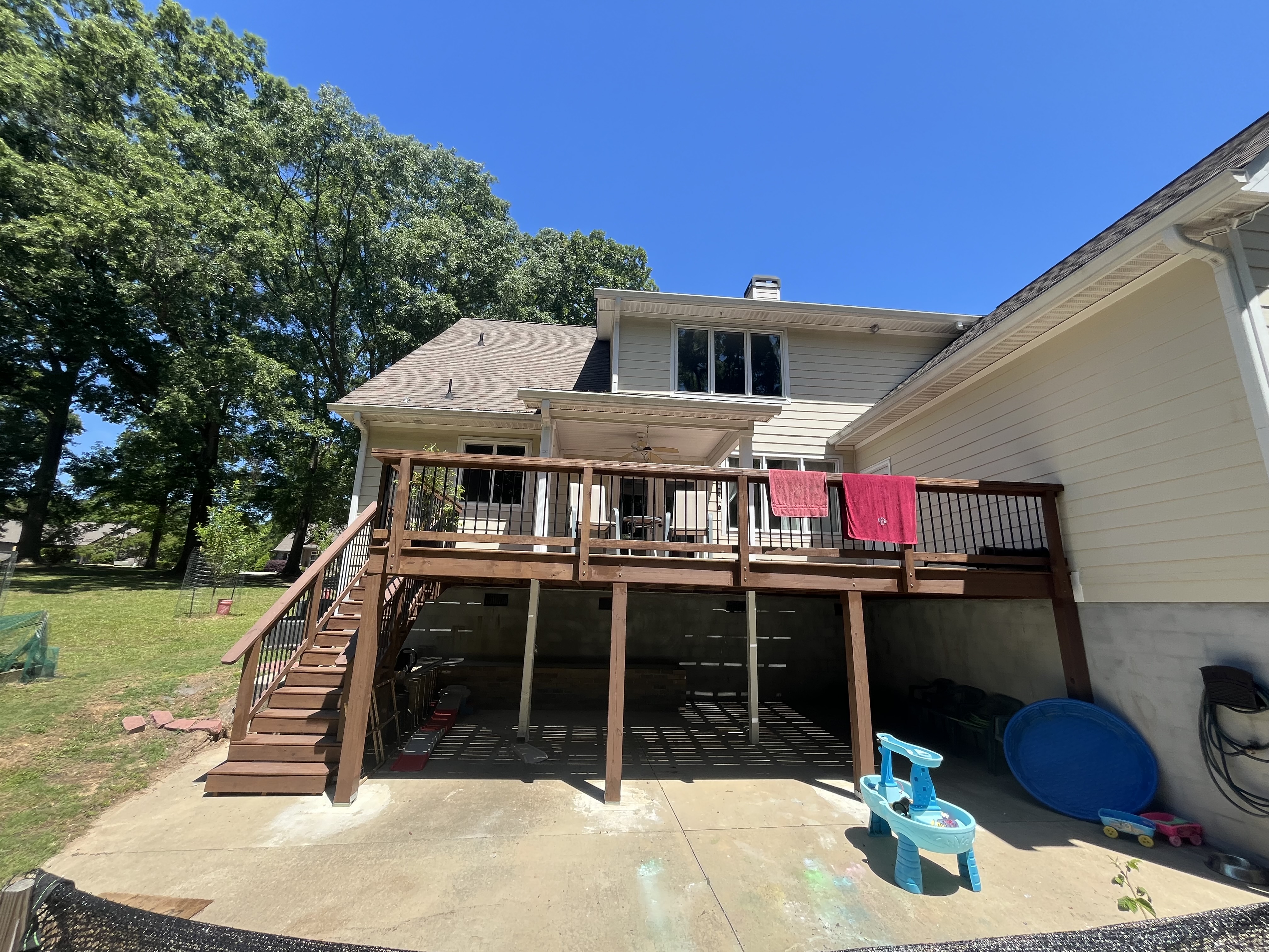 Elevated deck with black metal balusters, staircase and covered porch
