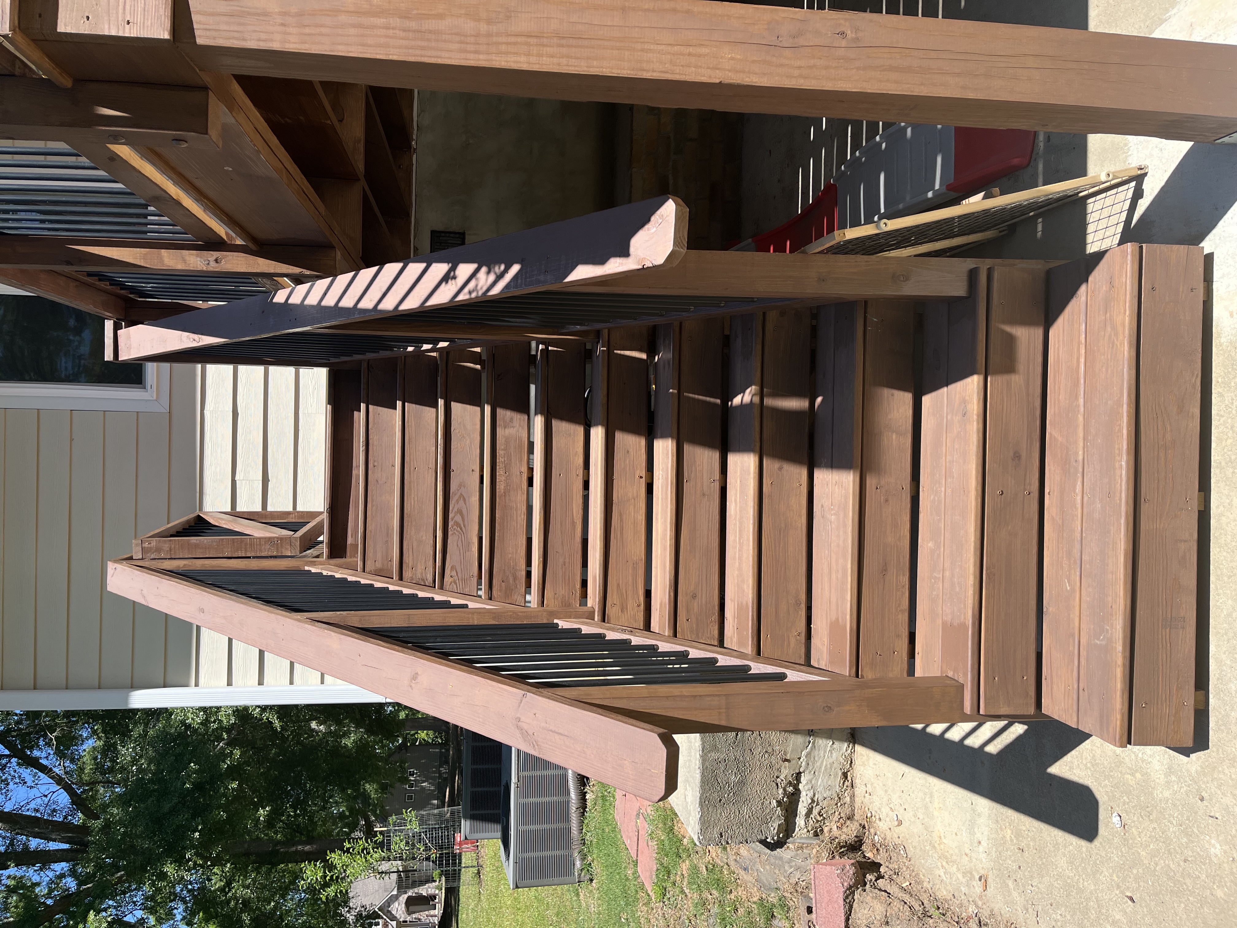 New stained deck staircase with black metal balusters