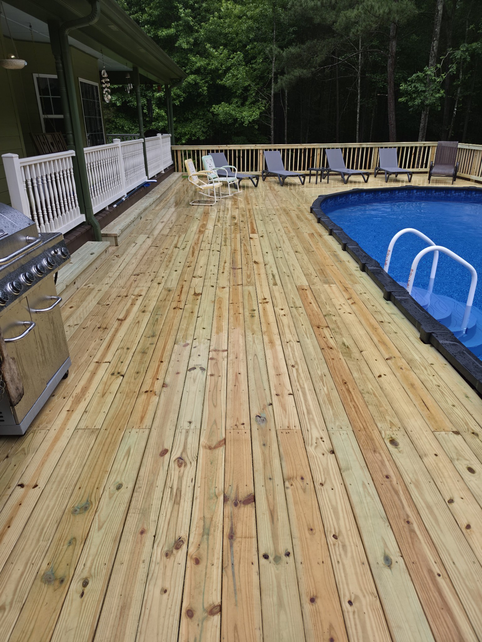 Wide pool deck with outdoor seating and above-ground pool