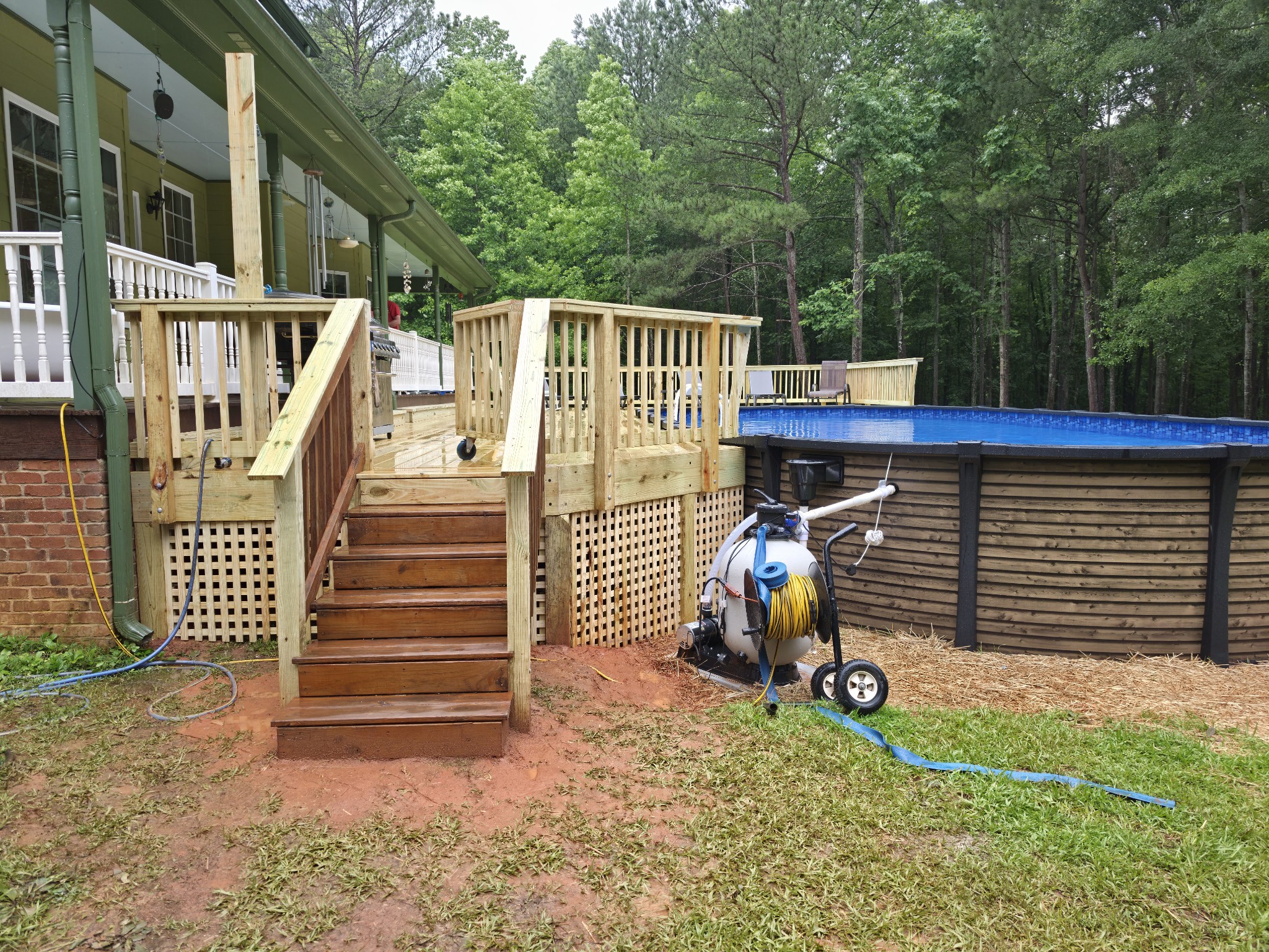 New pool deck staircase with above-ground pool surround