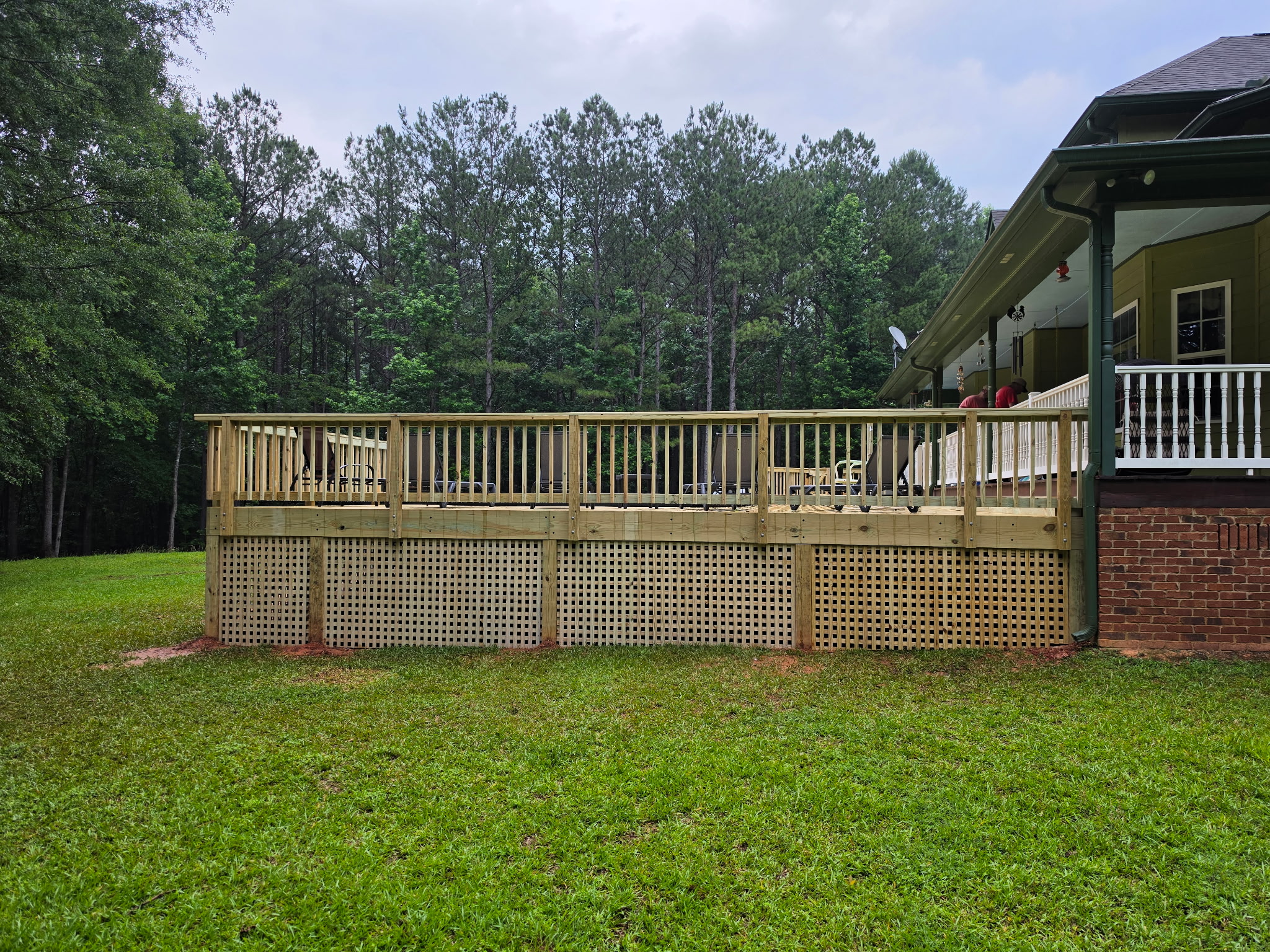 Elevated deck with lattice skirting and wood baluster railings