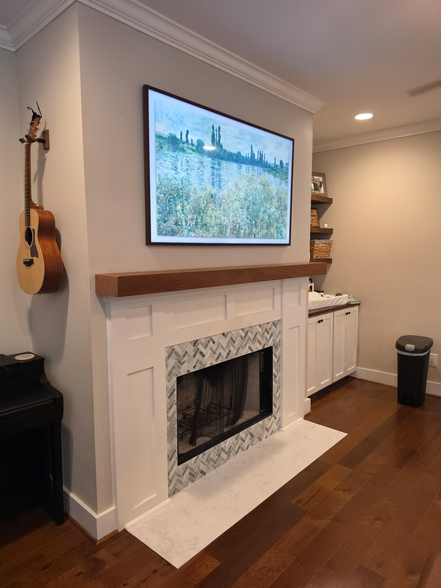 Fireplace after renovation with herringbone marble tile surround and fresh paint