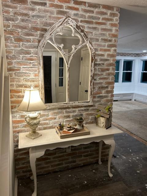 Exposed brick accent wall with console table and statement mirror