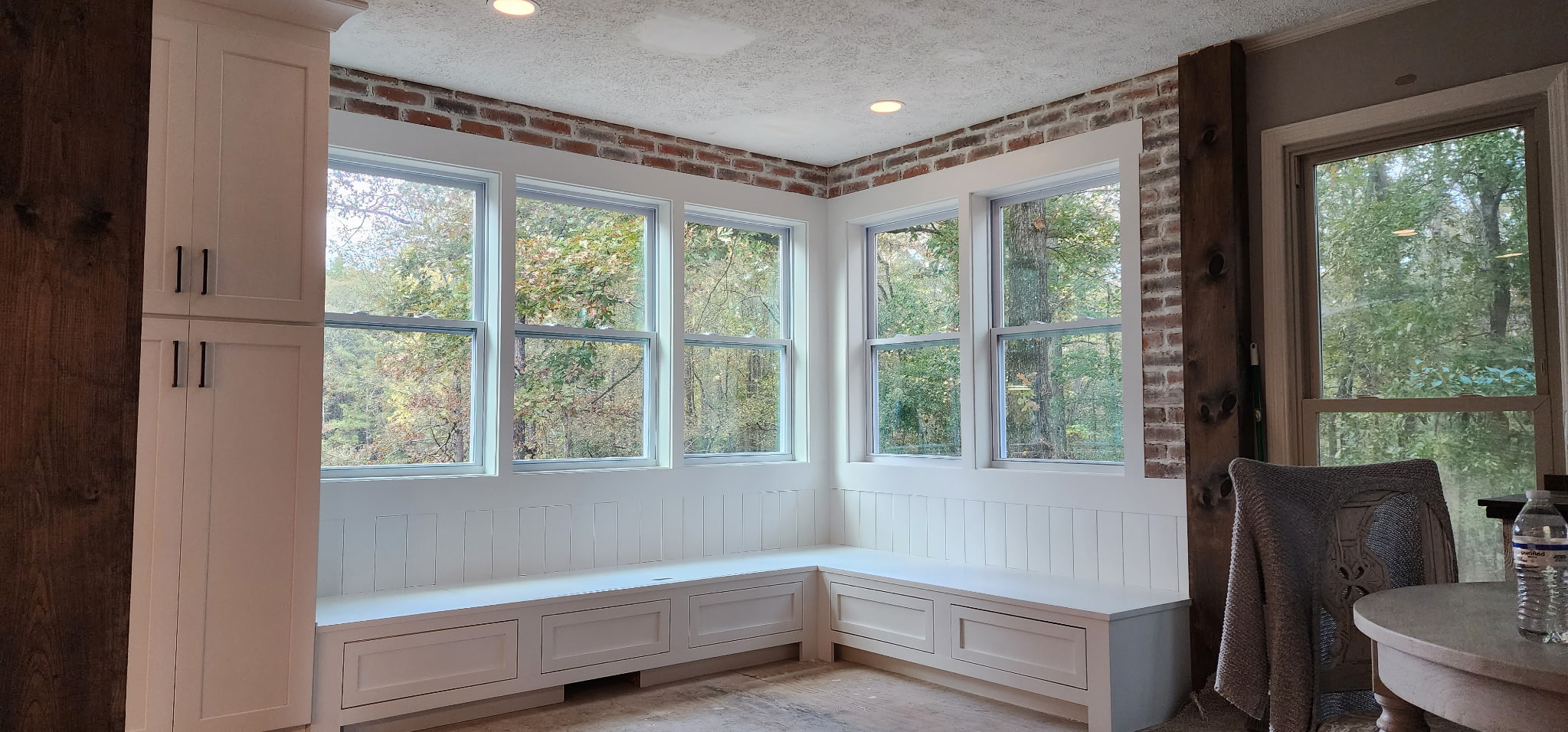 Bay window breakfast nook with built-in bench seating and exposed brick